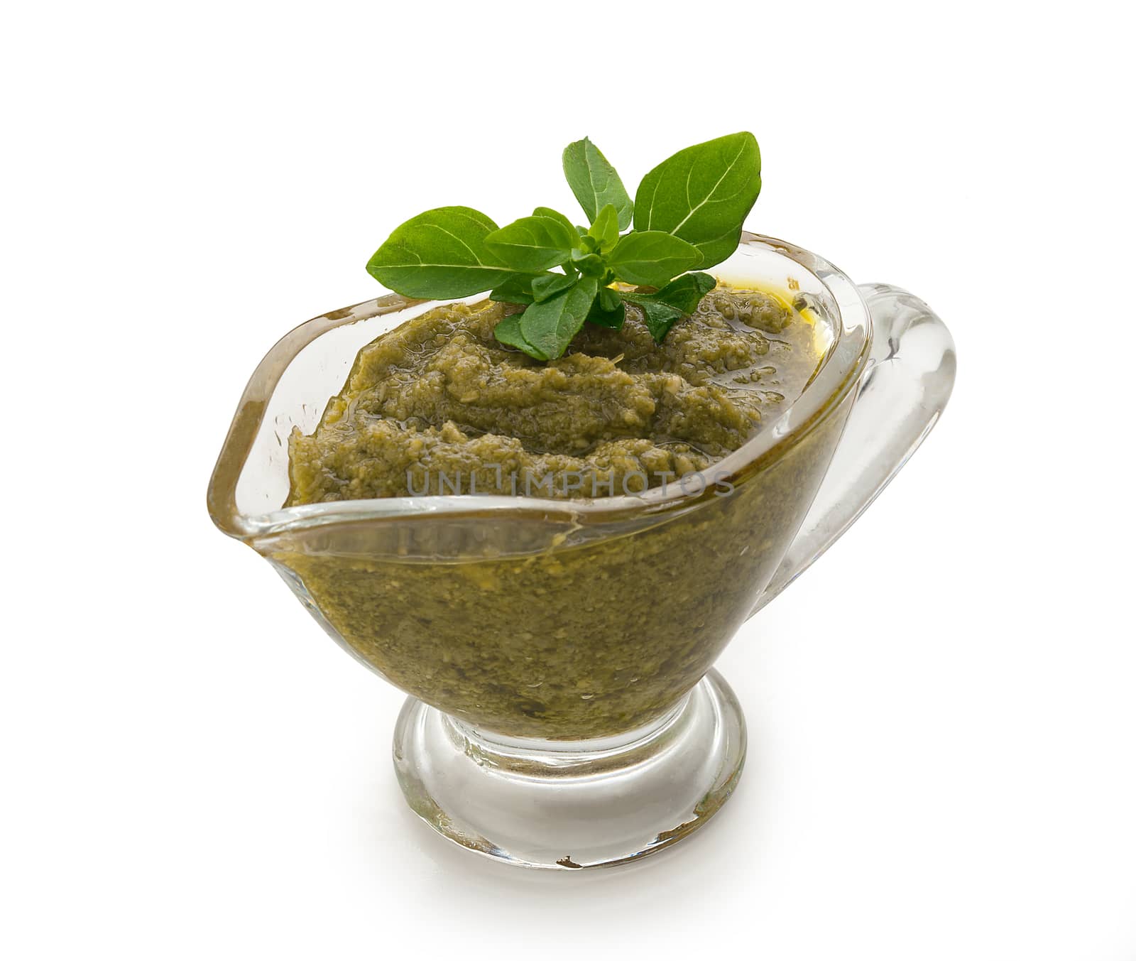 Pesto sauce in the gravy boat on the white