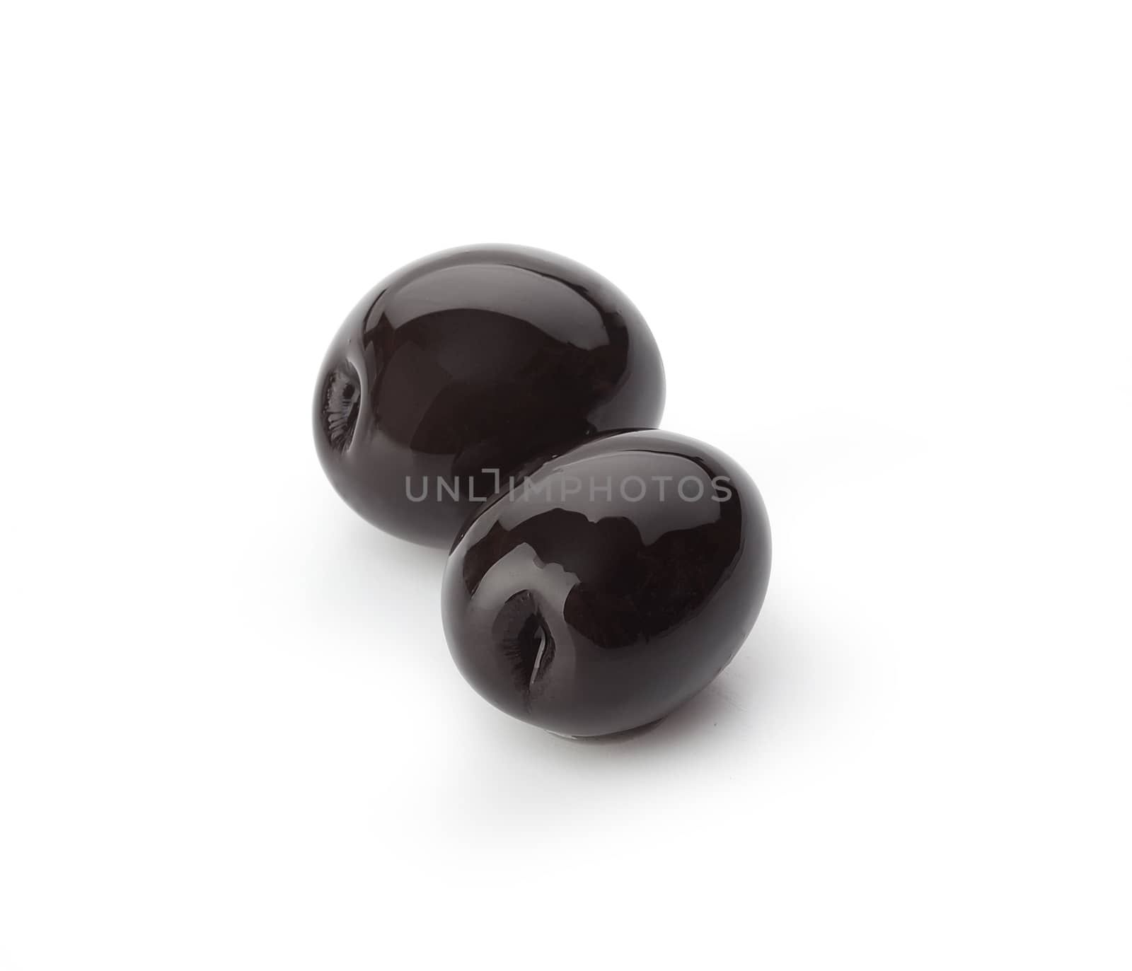 Two glossy black olives on the white background