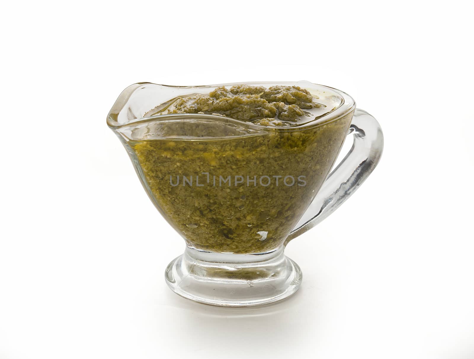 Pesto sauce in the gravy boat on the white