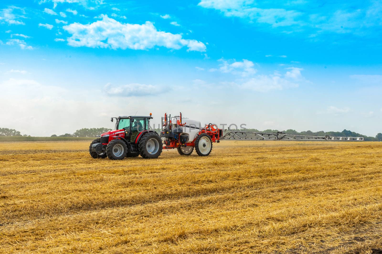 tractor with sprayer drives across the field