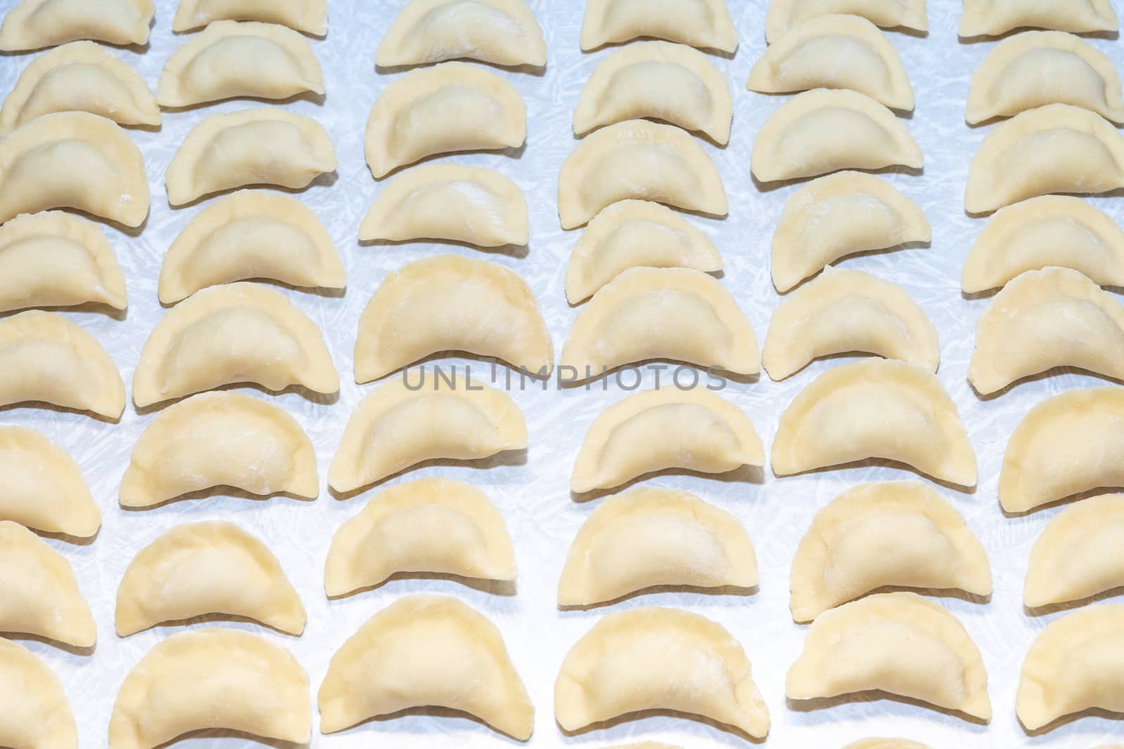 homemade delicious handmade dumplings are dusted with flour and await cooking by Serhii_Voroshchuk