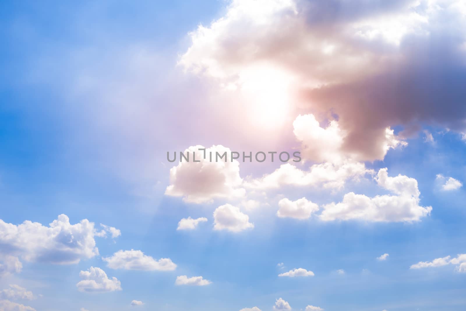 The clear sky view with white clouds and sunlight.