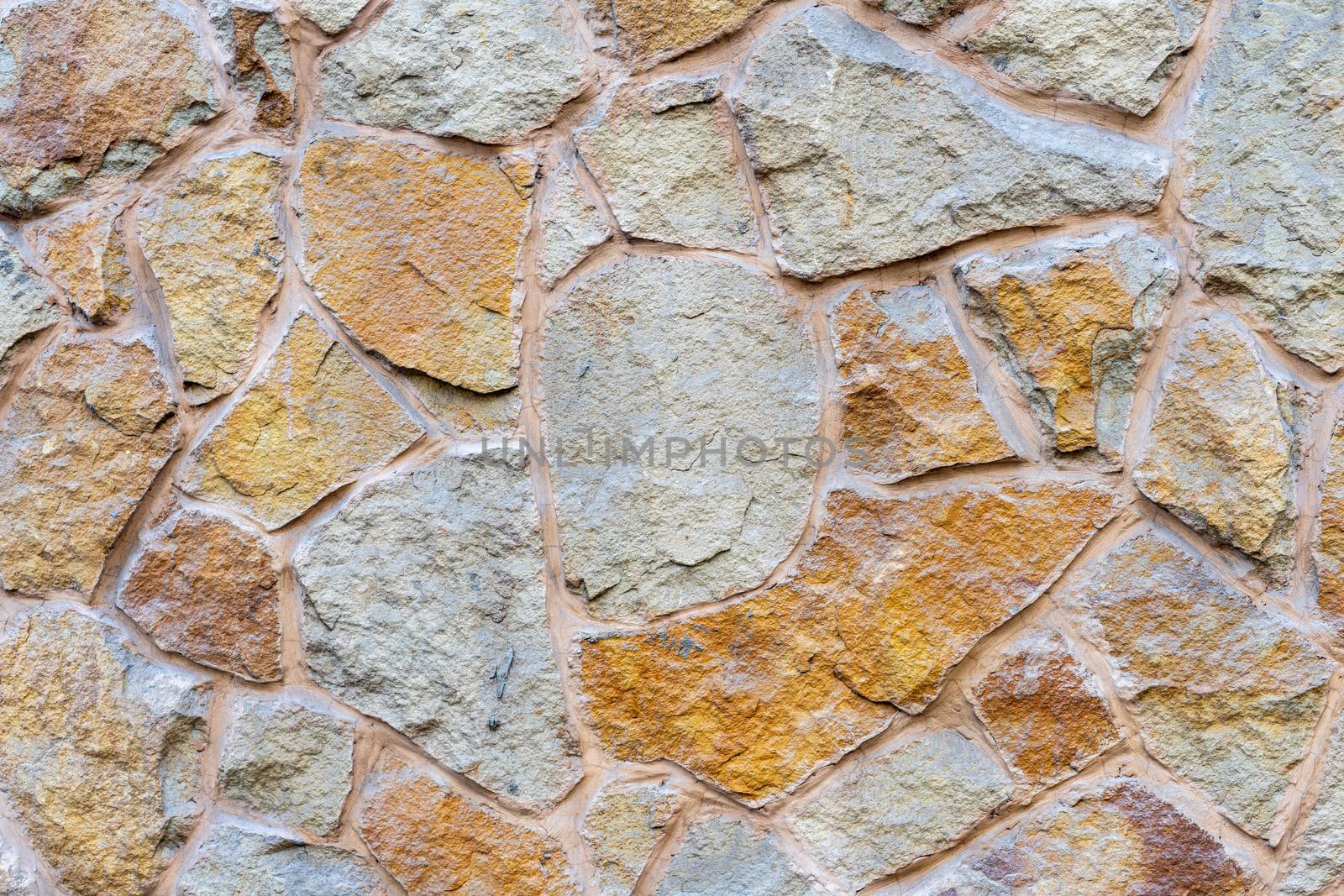 The wall is built of large yellow stone bonded with cement by Serhii_Voroshchuk