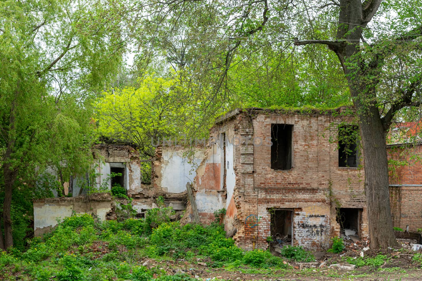 Old dilapidated red brick house without windows and roof