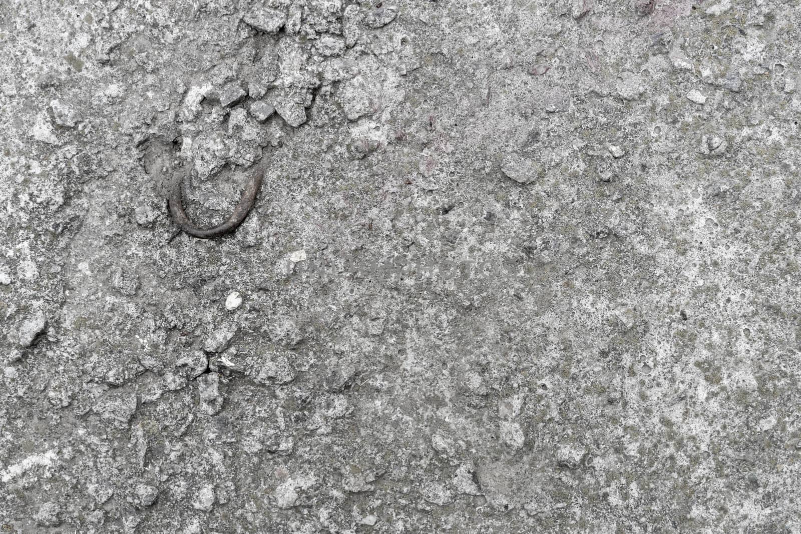 Old concrete slab with a bent metal hook. Background texture