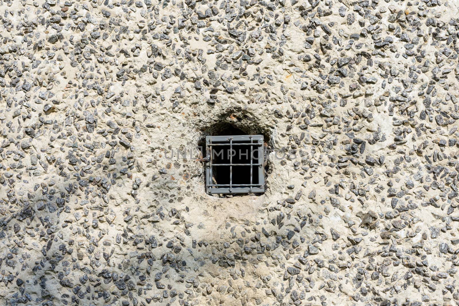 Concrete wall with a metal lattice in a small hole