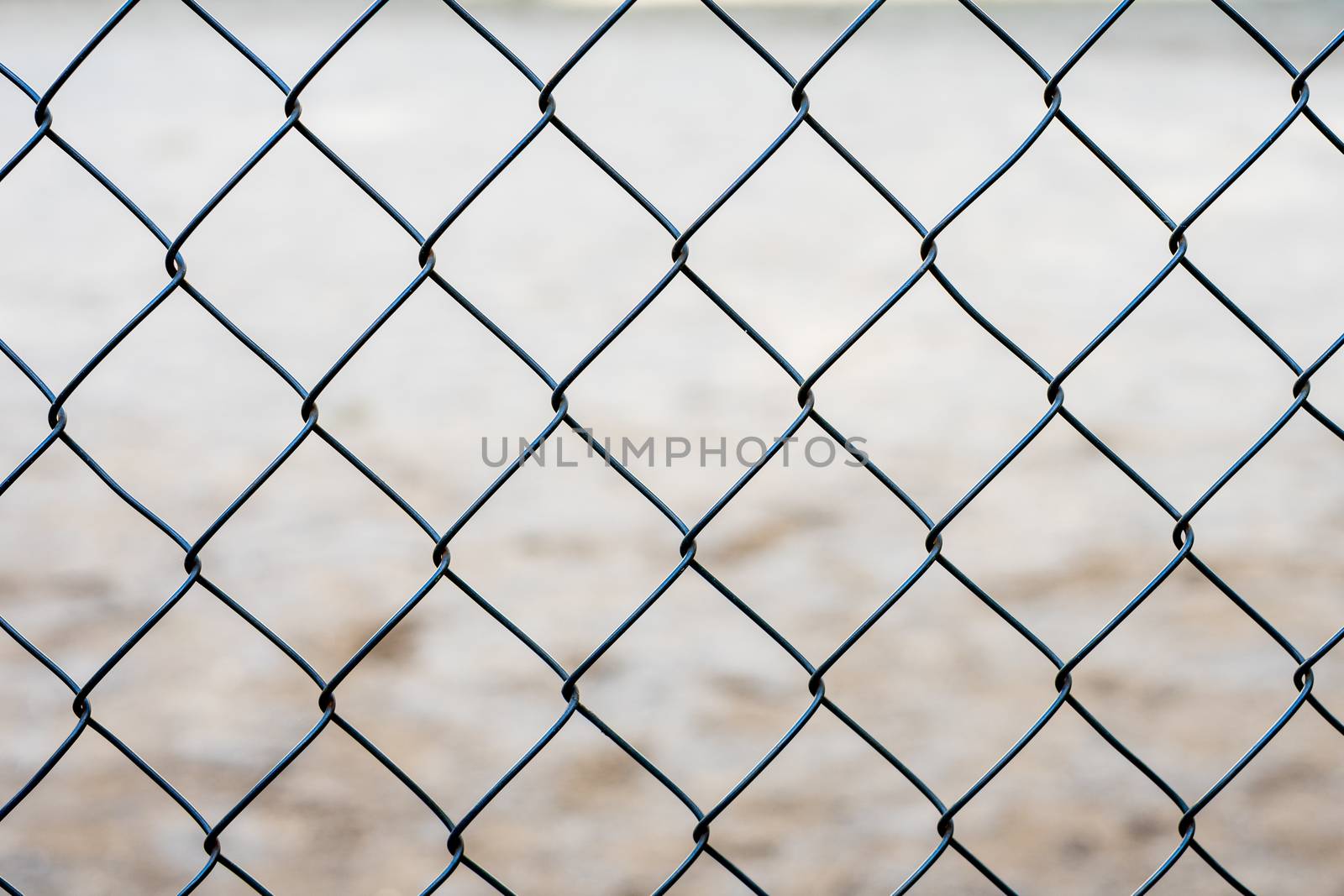 Stretched metal mesh on a blurred background . Fence from a metal grid