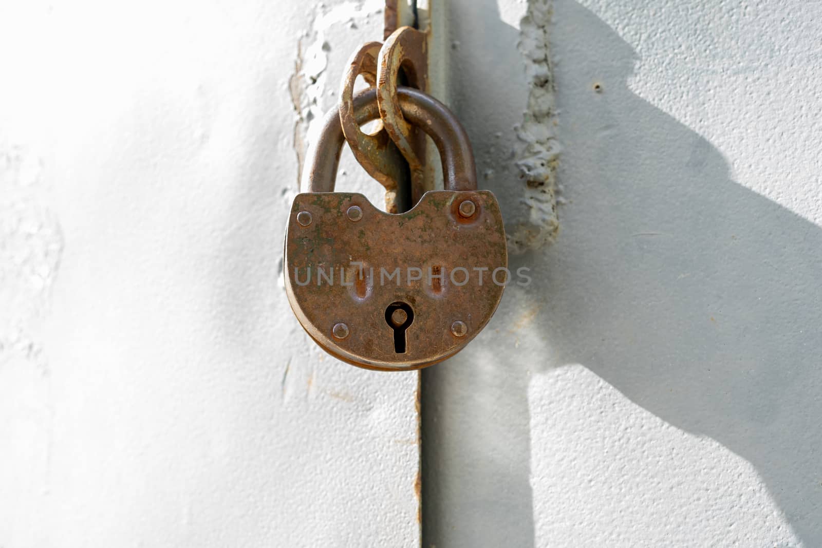 The metal doors are closed with a large old metal lock