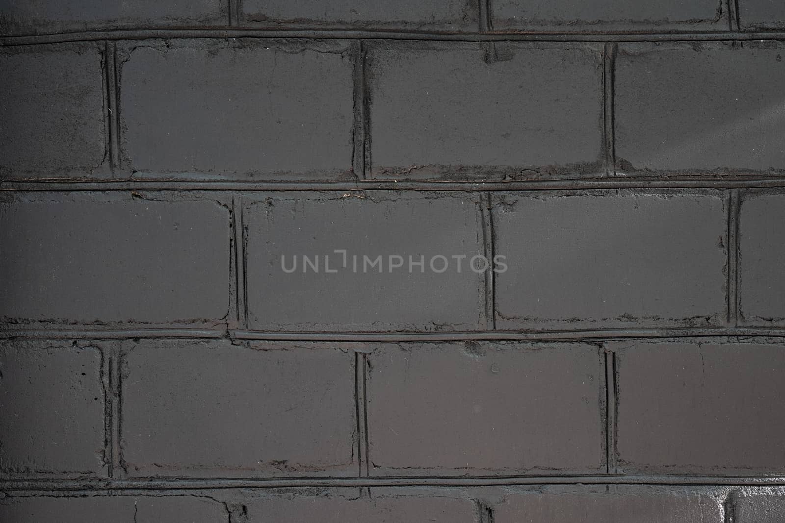 The brick wall of white, large bricks is painted black by Serhii_Voroshchuk