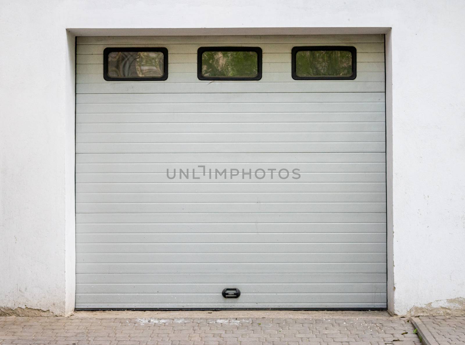 White garage door. Automatic gate with three windows. Wood texture