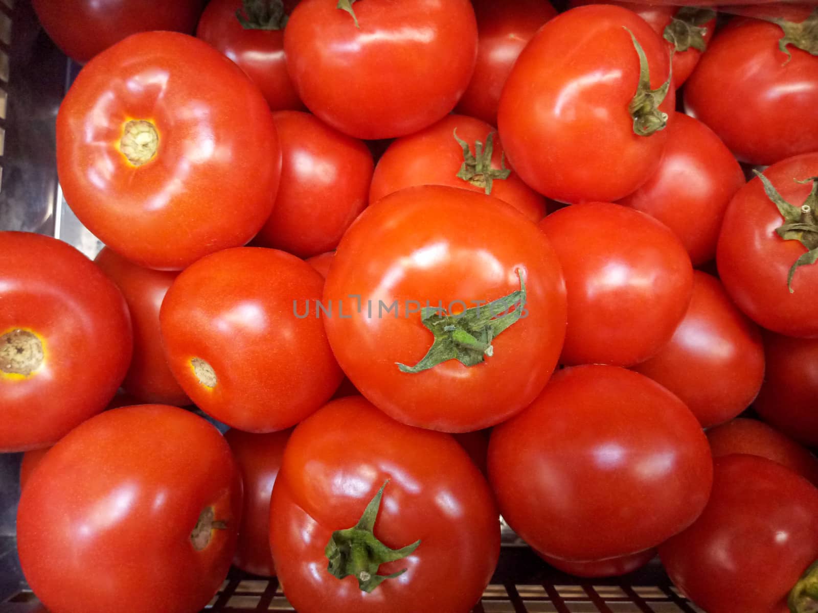 Ripe red tomatoes lie on the mound