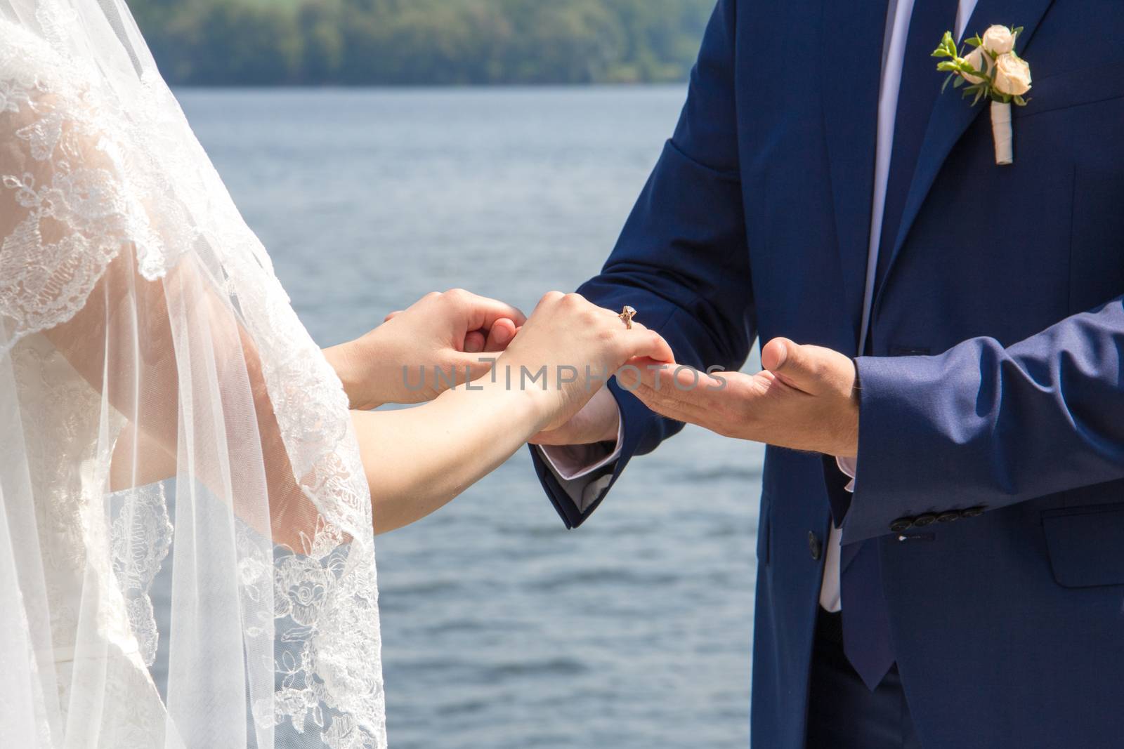 The bride and groom gently hold hands.