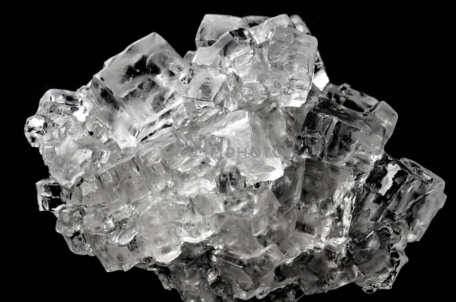 Cubic salt crystal aggregate against black background by geogif