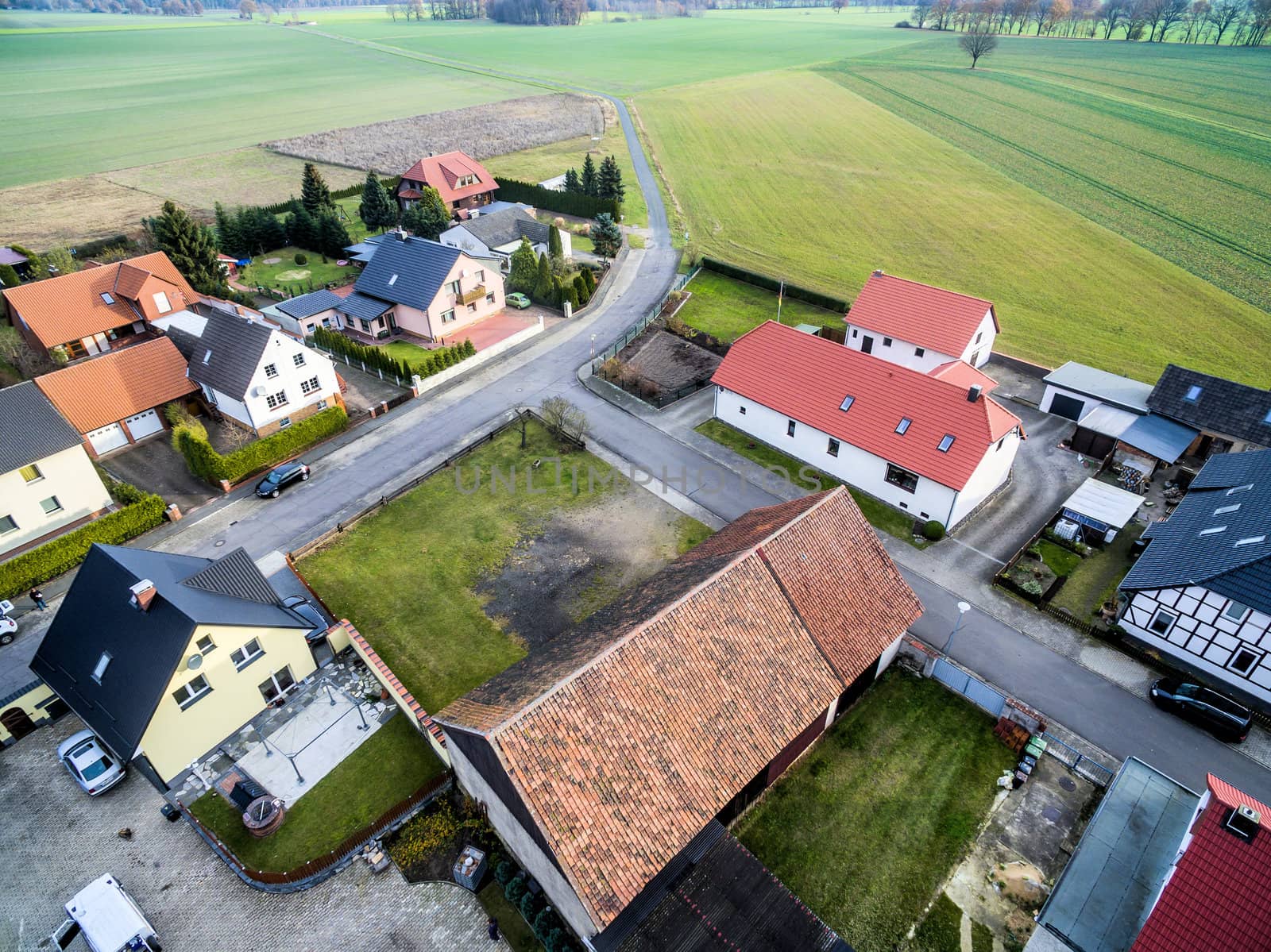 Building development with single-family houses on the edge of a village near Wolfsburg, Germany, aerial view with drone, with fields and meadows in the background, oblique shooting angle