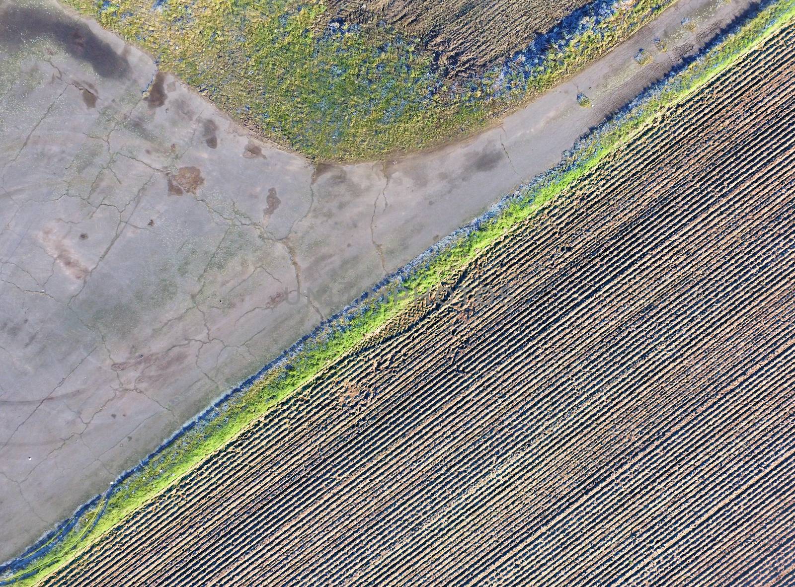 Abstract aerial photograph taken from a fork in the road with fields and meadows, aerial photograph taken with the drone