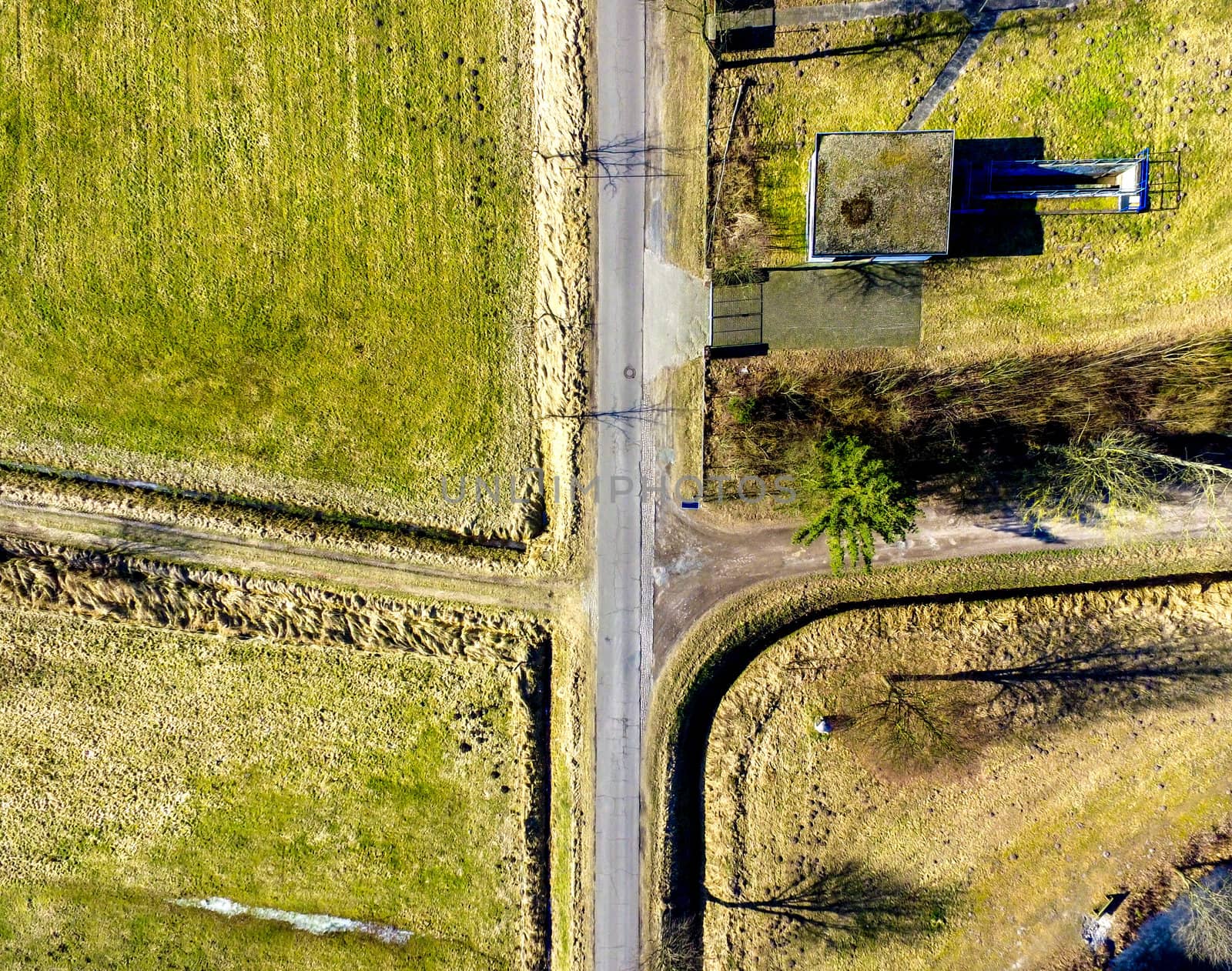 Aerial view of the crossing of a village road with two paths, meadows in the surroundings