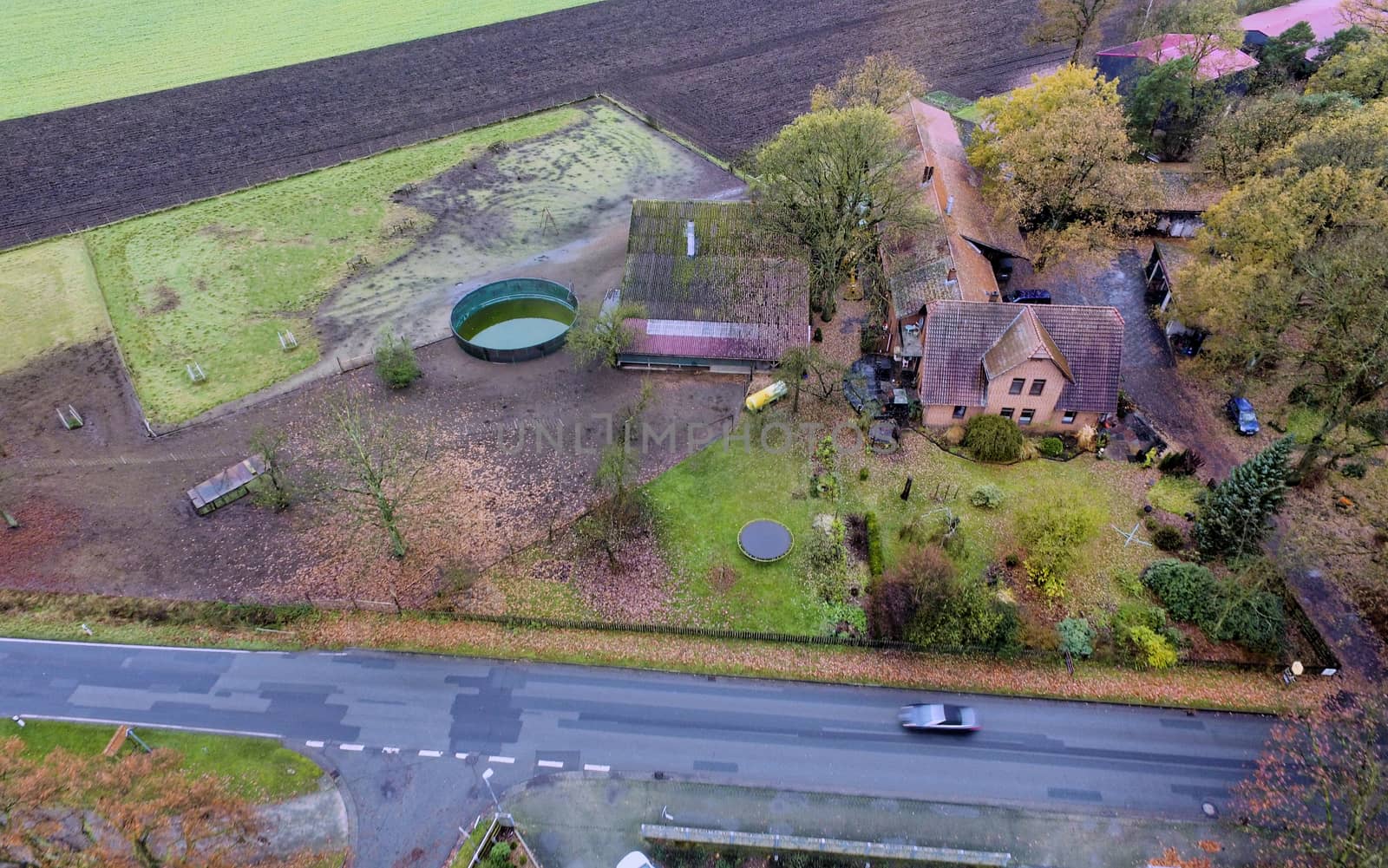 Aerial view of a farm in Germany with an asphalt road in the foreground