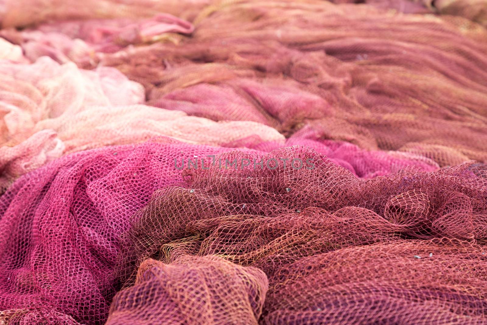 Red fishing nets drying on the port
