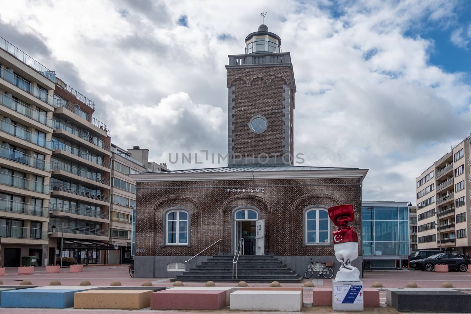 Knokke-Heist, Flanders, Belgium -  June 16, 2019: Knokke-Zoute part of town. Brick building with old lighthouse is office of tourism. Statue of candy wrapped in Indonesian flag with Islamic symbol.