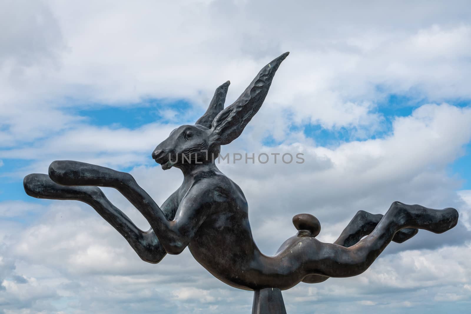 Knokke-Heist, Flanders, Belgium -  June 16, 2019: Knokke-Zoute part of town. Closeup of hare statue at end of boardwalk. Captured in only blue and white cloudscape.