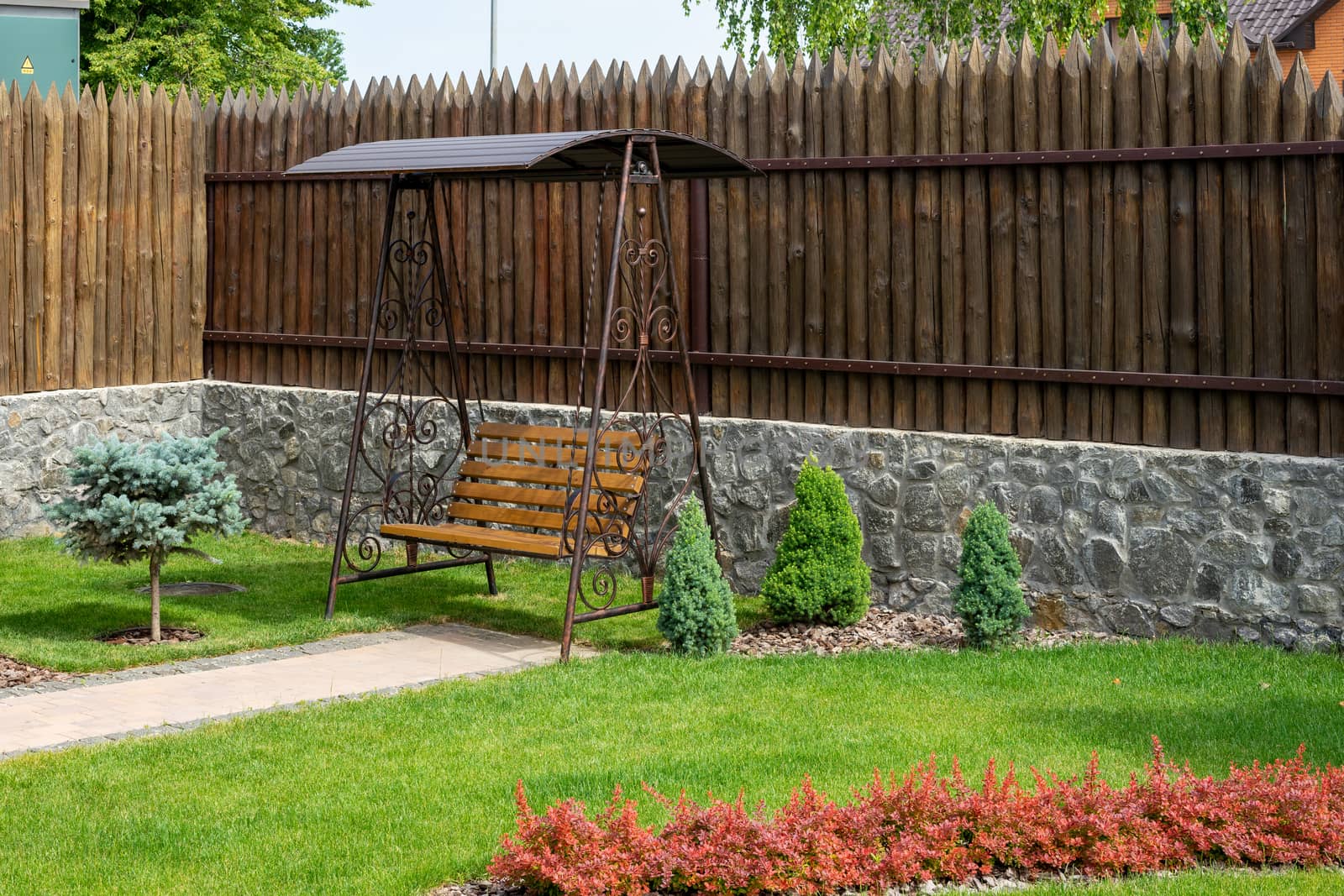 Swing under cover in the yard. A cozy corner