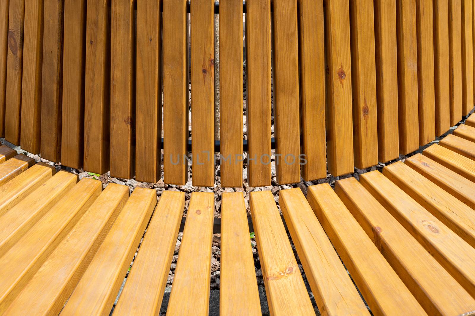 Bench with wooden boards close up. Background from wooden boards arranged in a semicircle. Wooden bench round