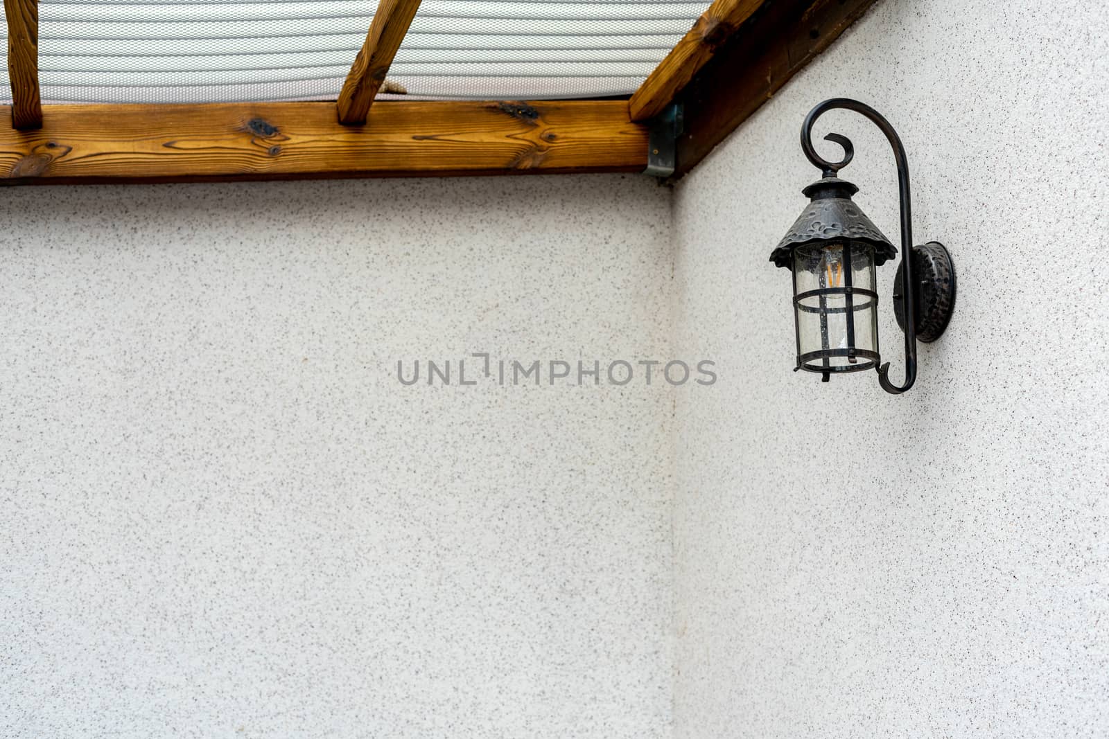 A black lamp is attached to the wall inside the house. Horizontal photo. Place under the inscription. by Serhii_Voroshchuk