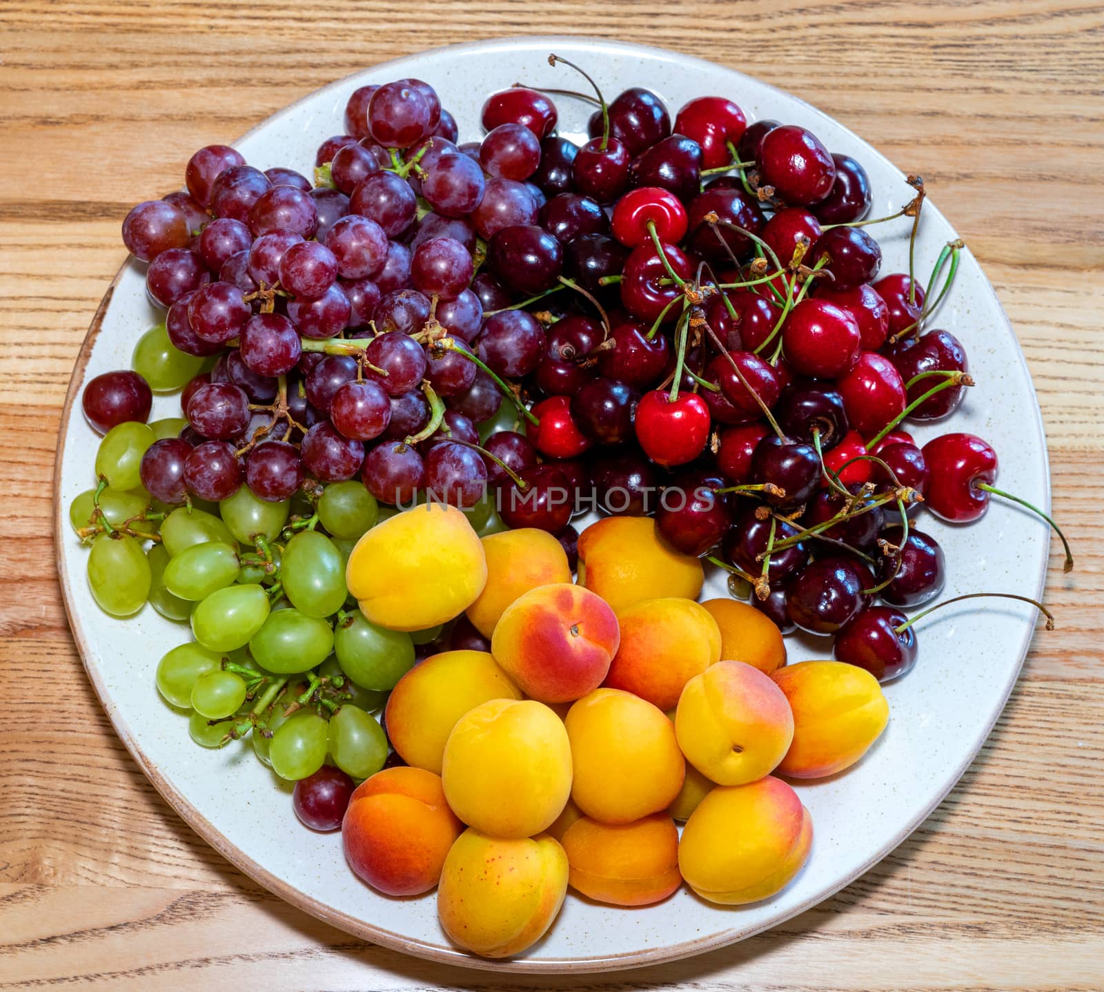 The plate with the fruit's sphysicists stands on the table. Ripe and Juicy Fruit