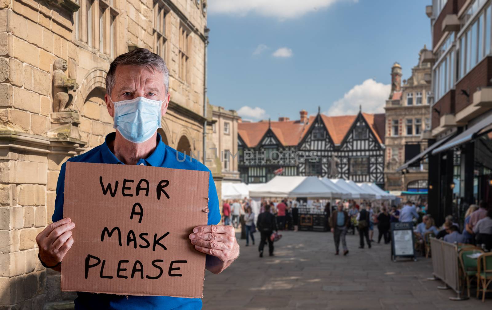 Senior man with face mask holding a cardboard sign with wear a mask message isolated against white by steheap