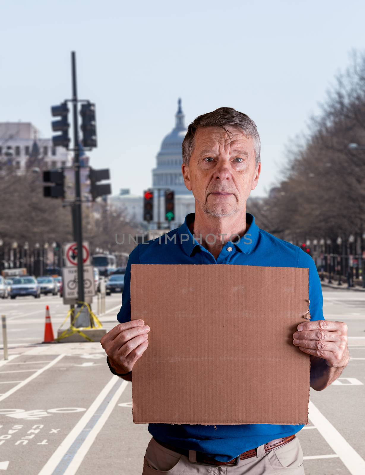 Senior caucasian man holding a blank cardboard sign for copy space message. He is composited into Washington DC street scene