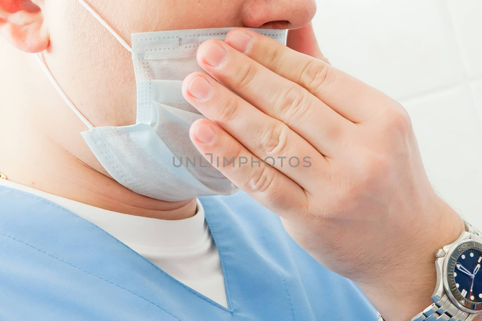 A man or medical worker touches his face through a mask, puts on, corrects.
