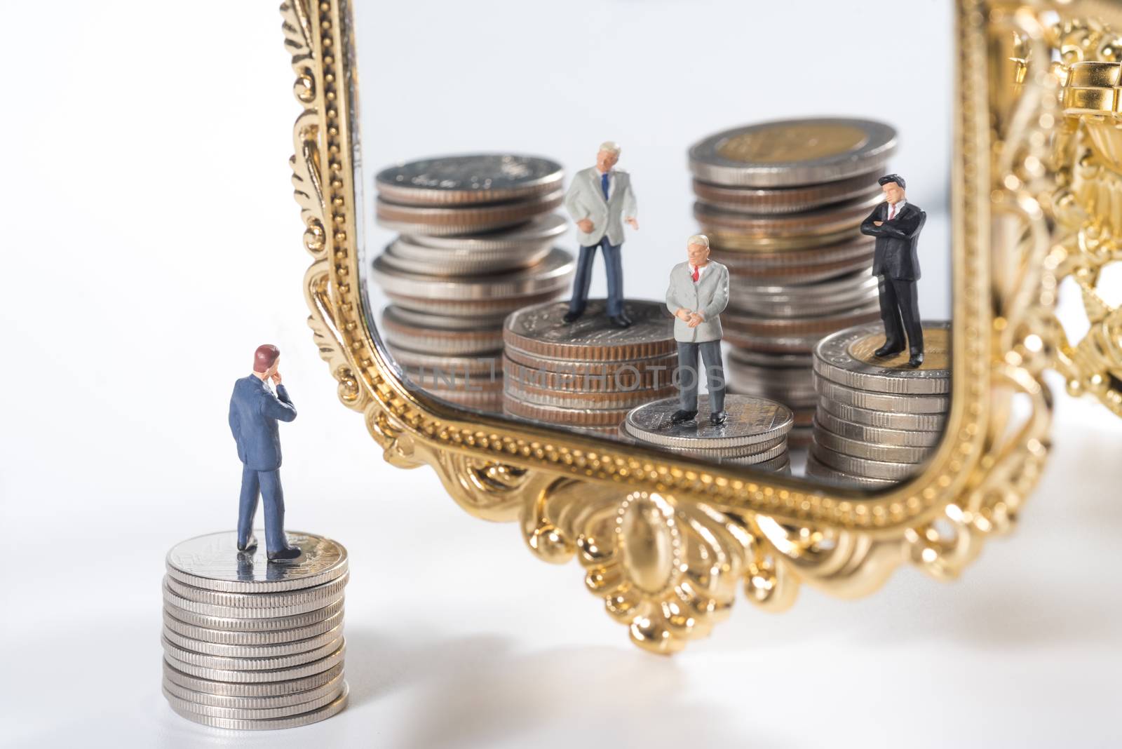 miniature businessmen see wealthy team in the mirror