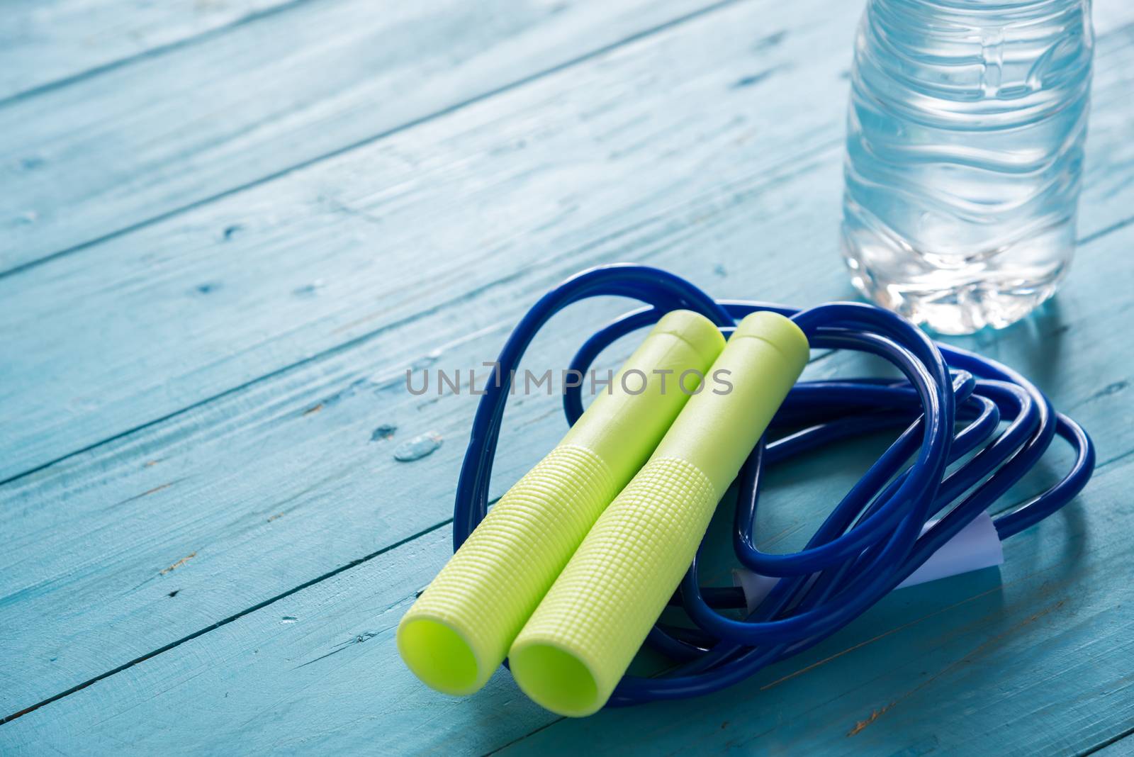 skipping rope and water bottle for an exercise on wood table