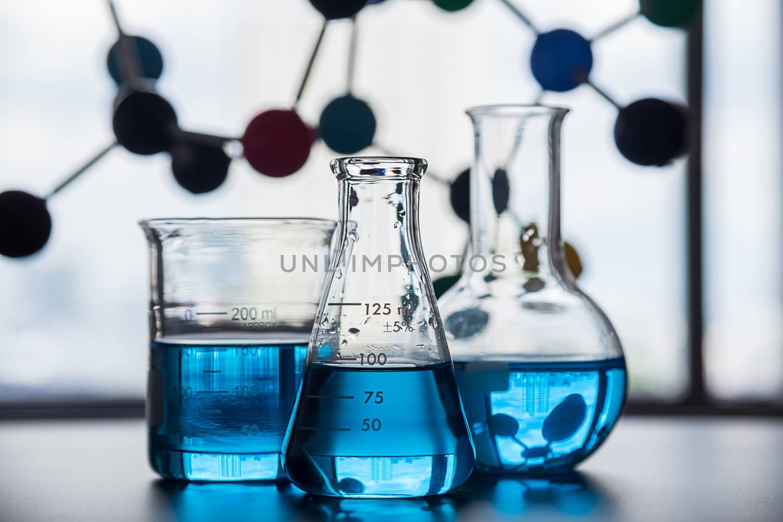 science laboratory beaker, erlenmeyer flask and molecule structure model, laboratory equipment concept