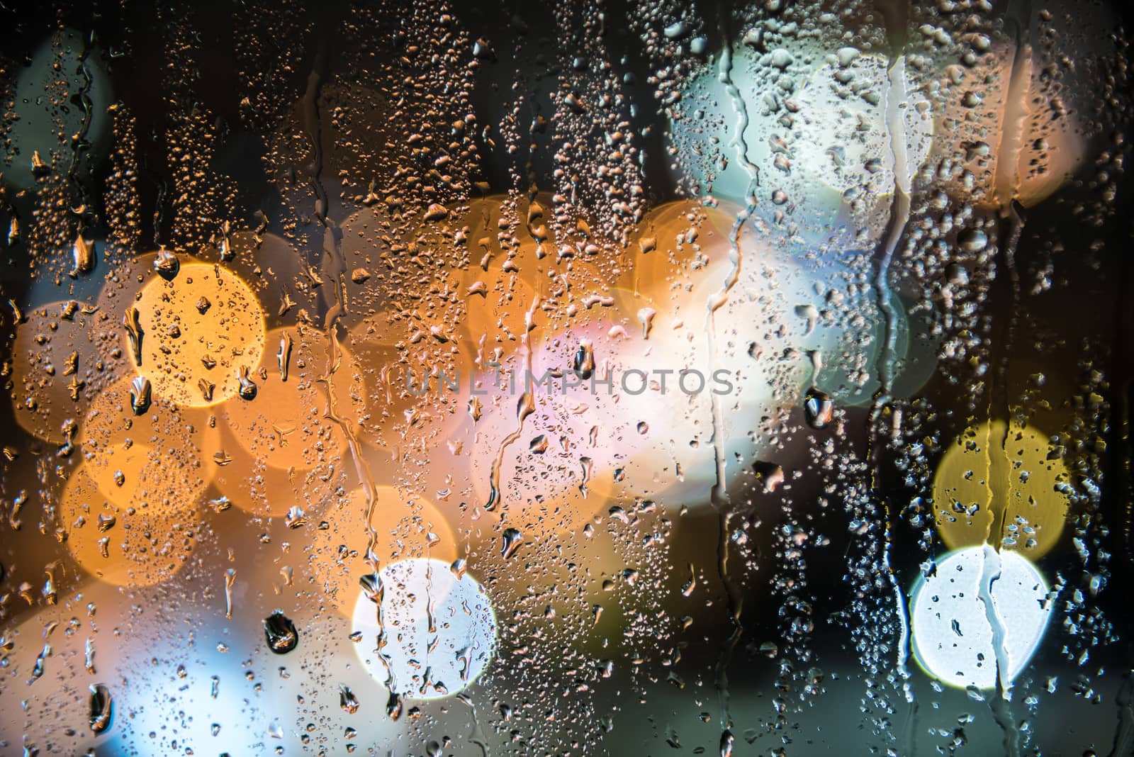 natural water drops on glass window with night city bokeh background