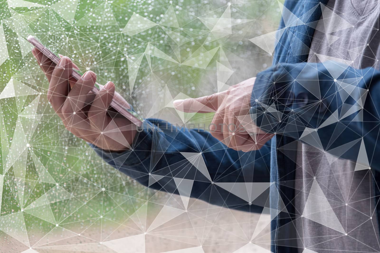 man hand using smart phone with water drop on glass windows background