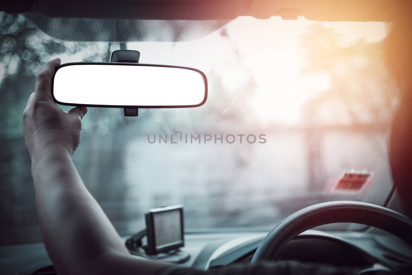 man hand adjuct rear view mirror of a car