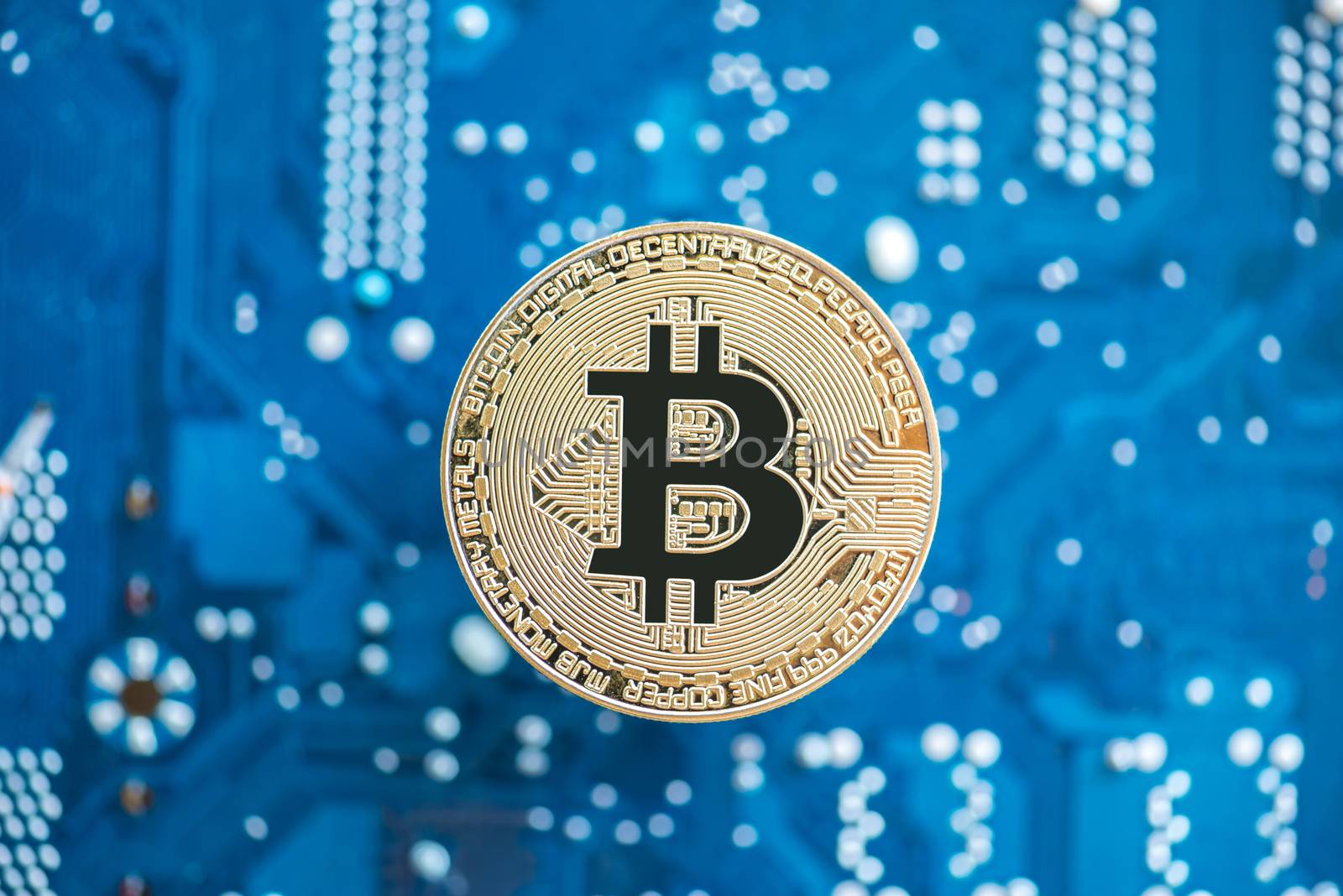 gold bitcoin on blue mainboard background
