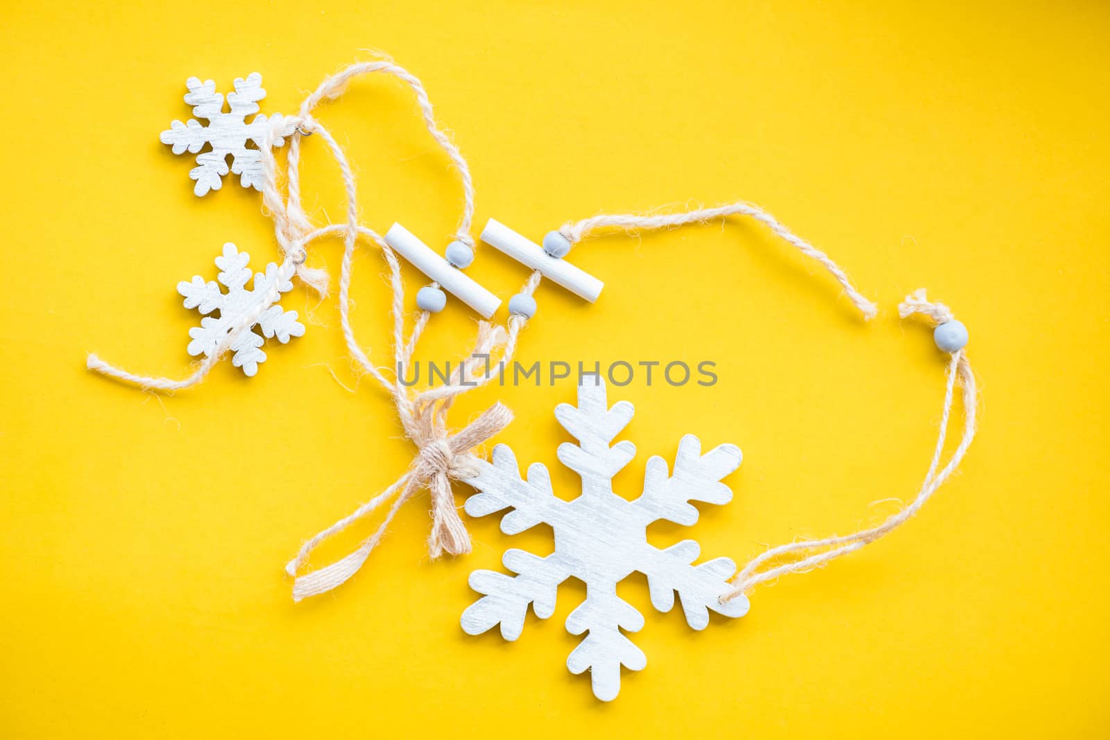 white wood snow flake on yellow paper background