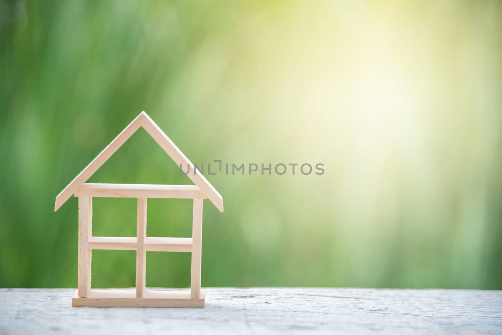 miniature wood house model on white wood and green natural background