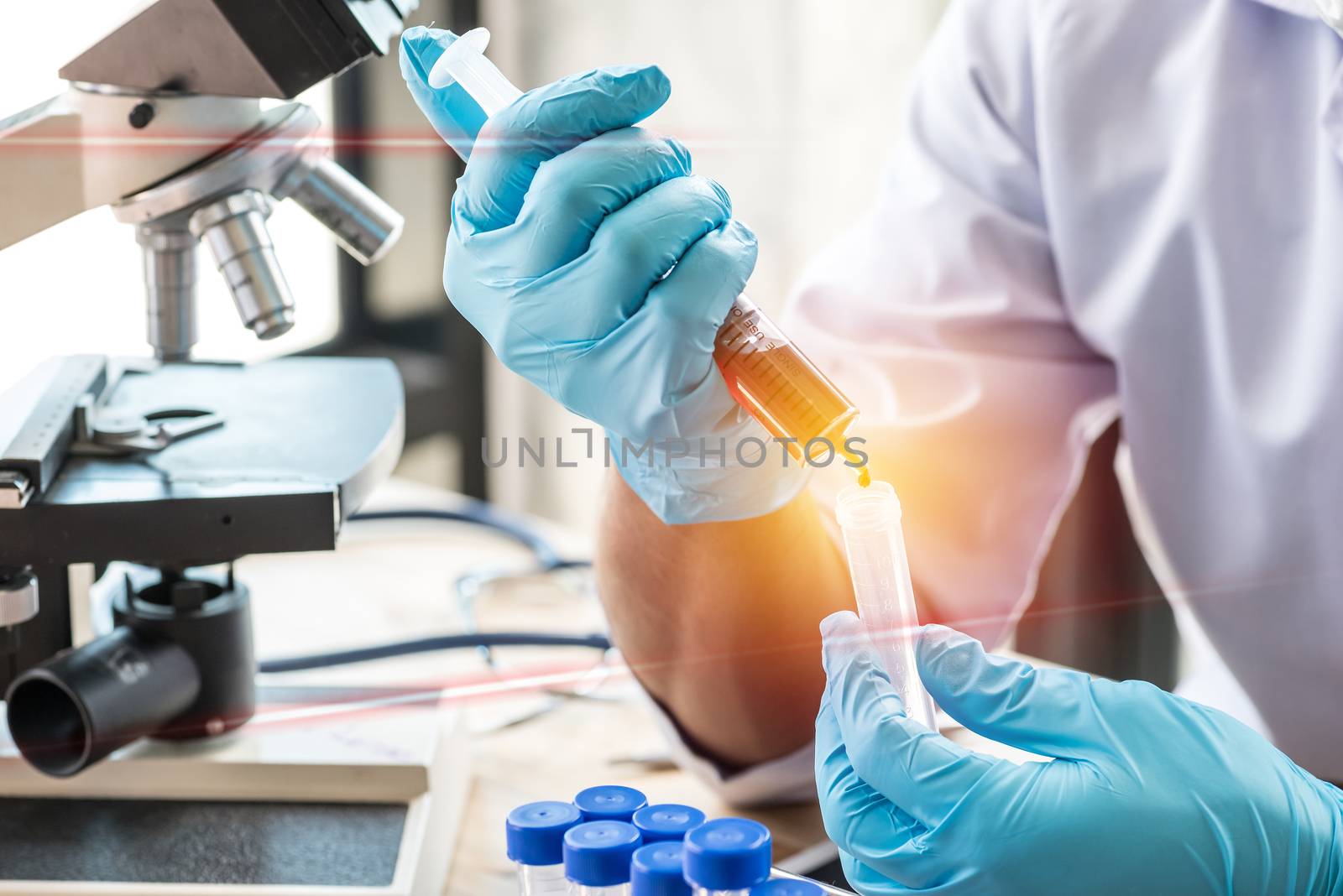 scientist or doctor dropping a blood into blood test tube in rack , research concept