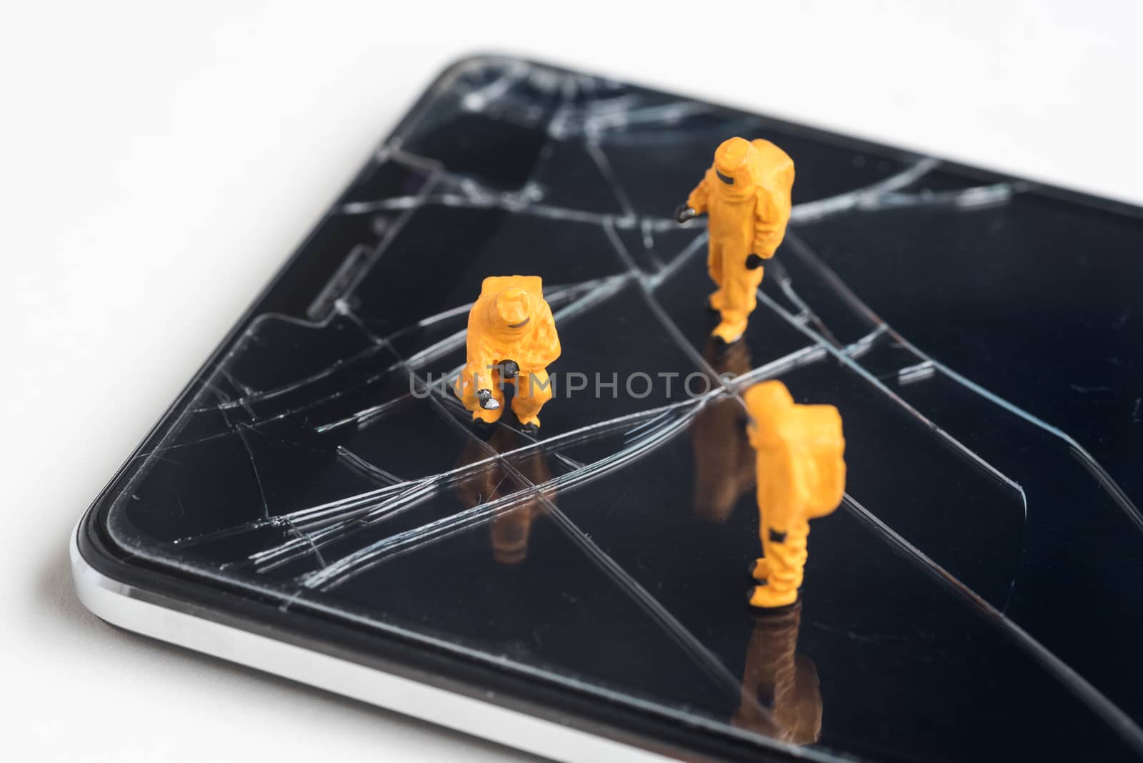 miniature people are inspect  the fracture on smartphone screen