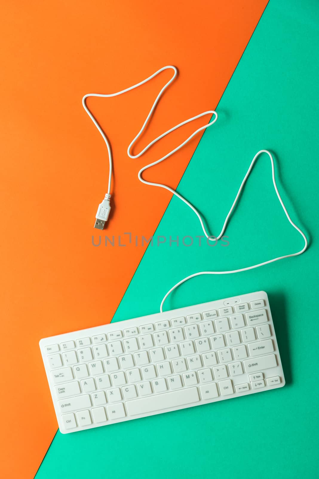 white computer keyboard on orange green background