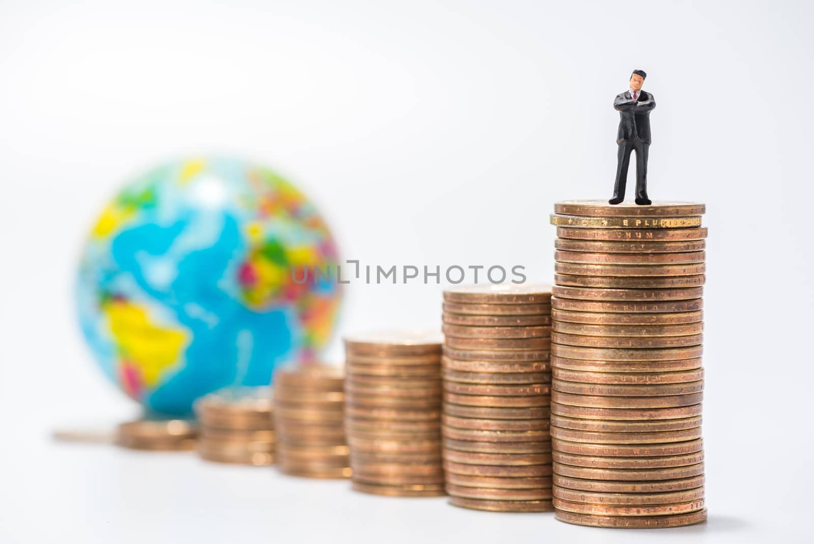 business miniature figure standing on stack of coins and globe figure background