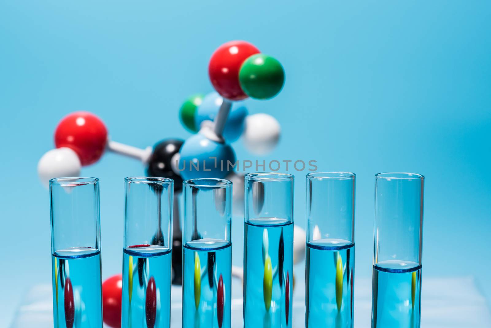 science laboratory test tubes and molecule structure model on light blue background , laboratory equipment