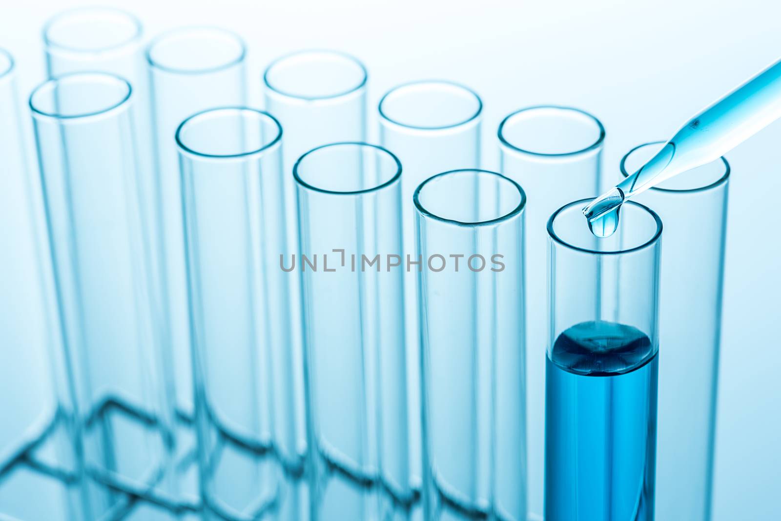 Experimental drops over science laboratory test tubes , science research equipment.