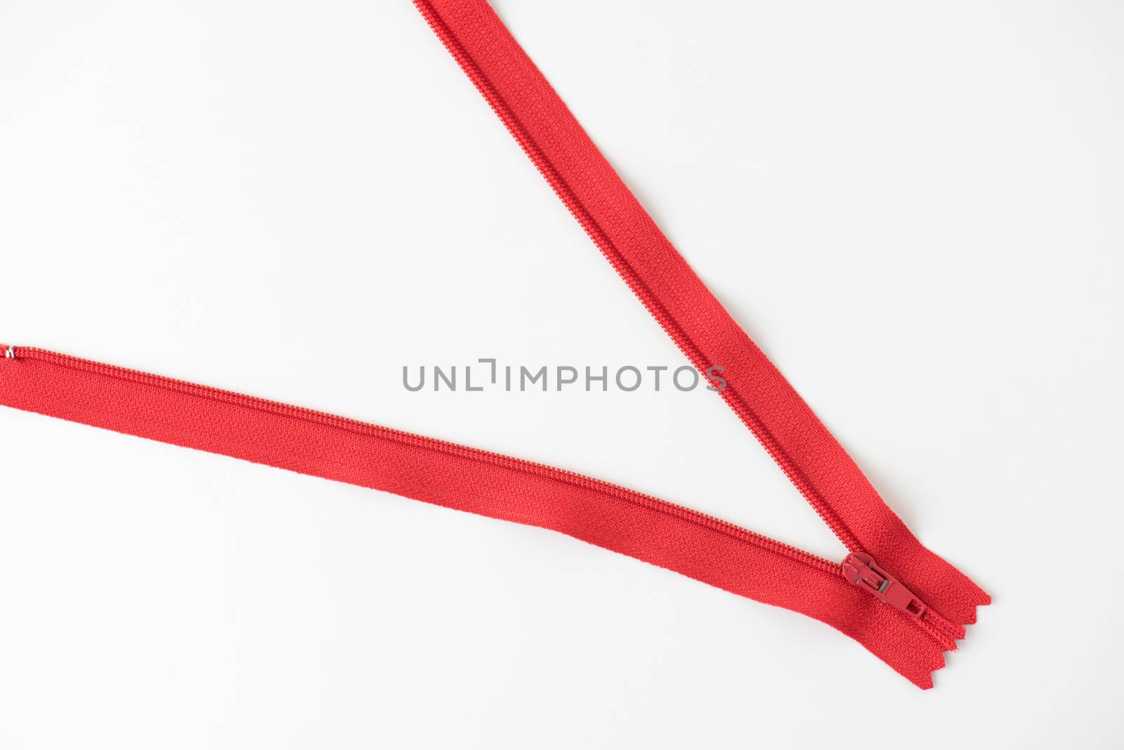 metal red zip on white background by Lerttanapunyaporn
