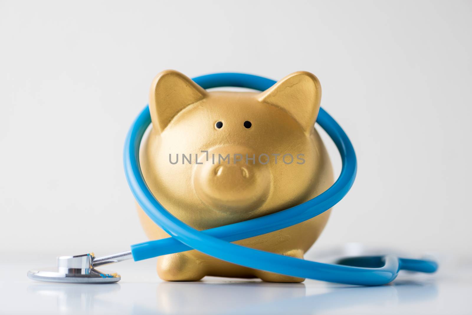 piggy bank with stethoscope on white background.