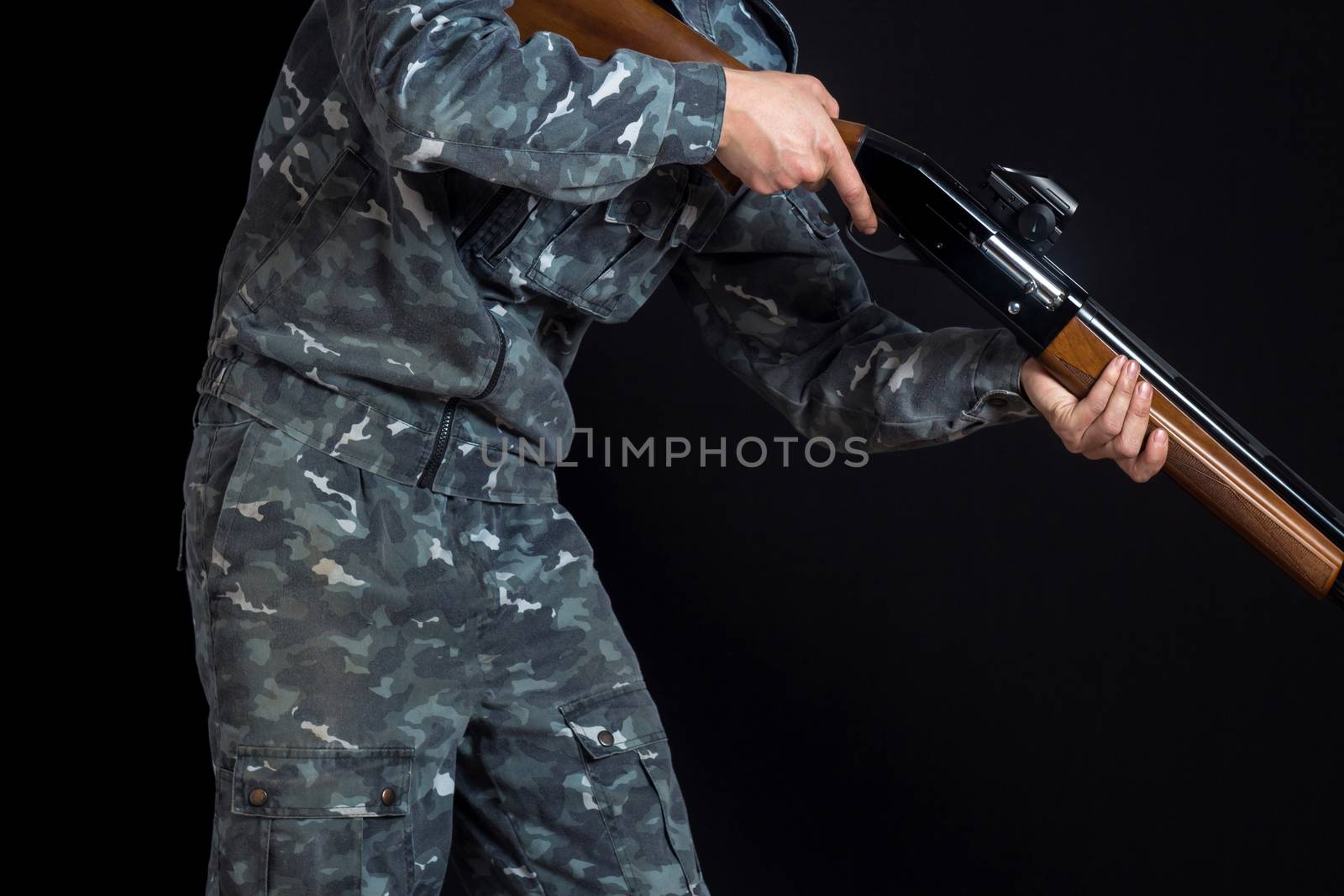 Military or hunter with a shotgun. A man holding a gun with a si by YevgeniySam