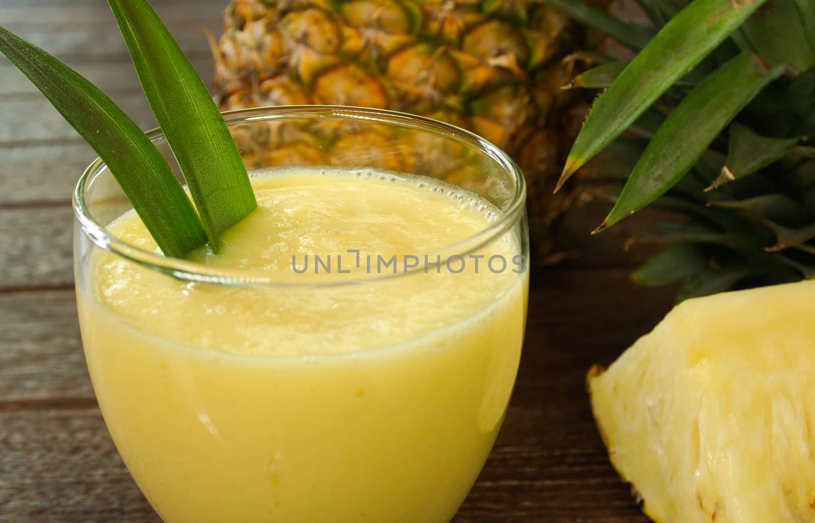 pineapple juice and pineapple on wood table. for health